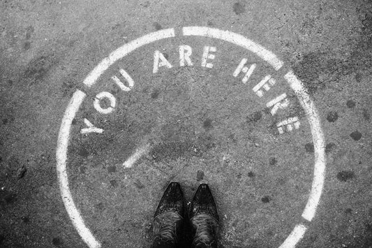 A person standing in a circle with the words 'You Are Here' inside of it