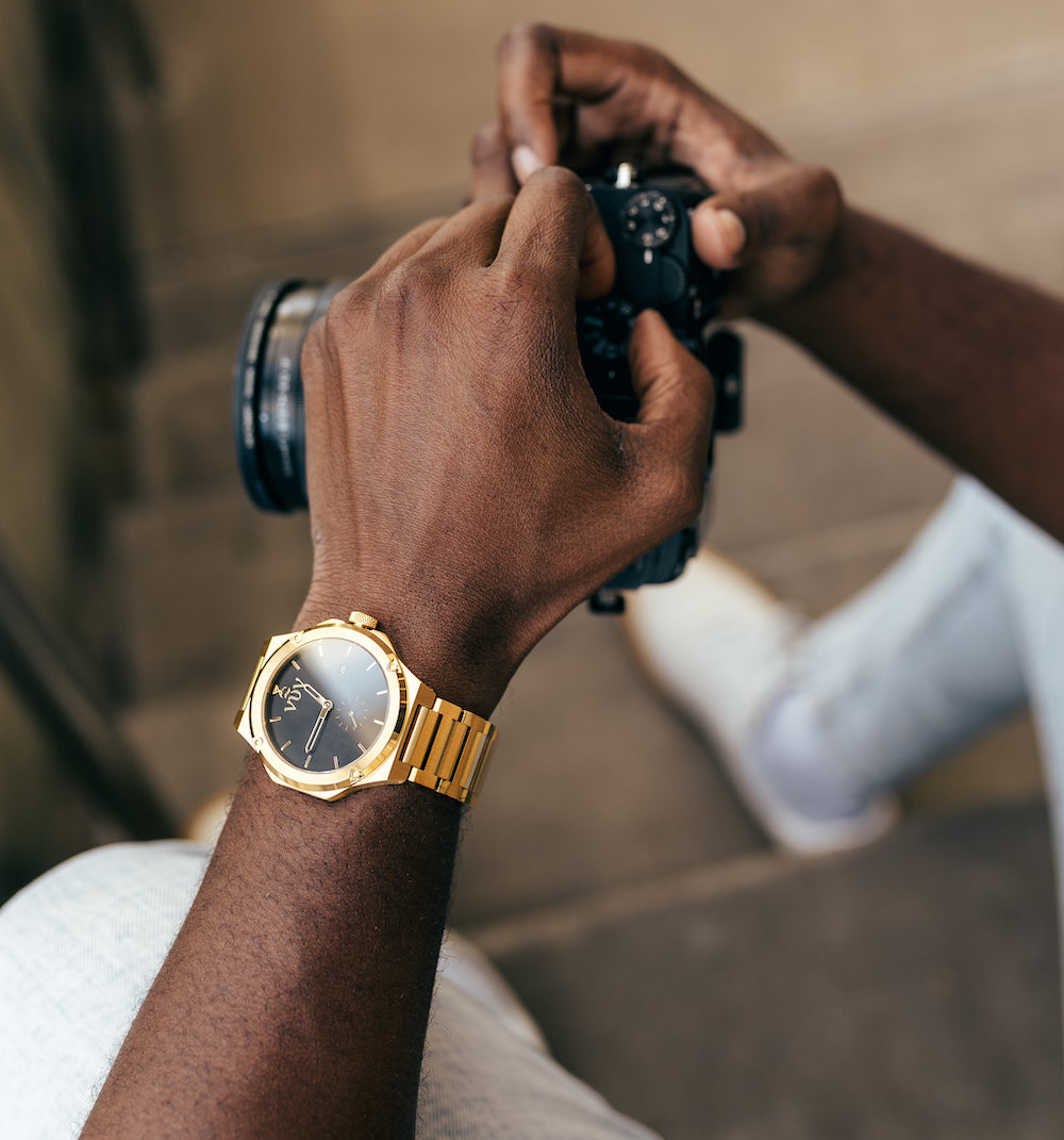 Gold Kairos on wrist of man hold camera